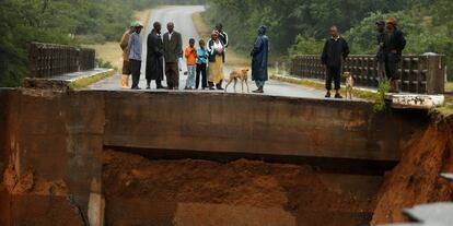 Los lugareños observan un puente quebrado sobre el río Umvumvu, tras el paso del ciclón Idai en Chimanimani (Zimbabue)