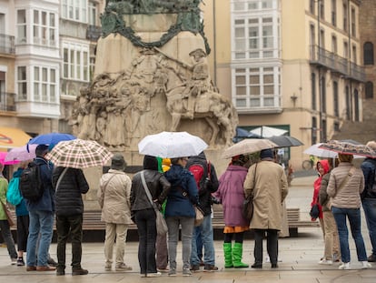 Un grupo de turistas se protege de la lluvia con sus paraguas en el centro de Vitoria este martes, en el que se registran las primeras precipitaciones del mes de mayo.