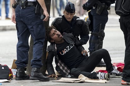 Un migrante se desmaya mientras es evacuado por la policía durante el desmantelamiento de un campamento temporal de inmigrantes principalmente de Sudán y Eritrea, en el norte de París (Francia.