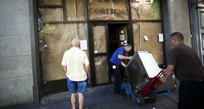 Dos empleados transportan un mueble durante el cierre del Café Comercial.