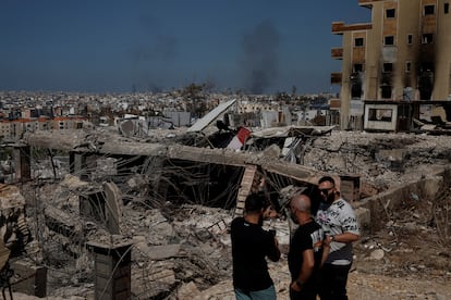 Varios hombres hablan junto a los escombros generados por el ataque, este jueves en el sur de Beirut.