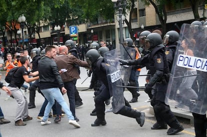 Agents de la Policia Nacional intenten retirar els concentrats en un IES de Tarragona.