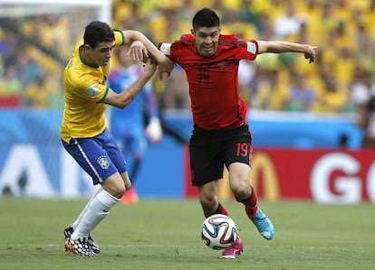 O atacante mexicano Oribe Peralta tenta se desvencilhar do meia brasileiro Oscar dos Santos.