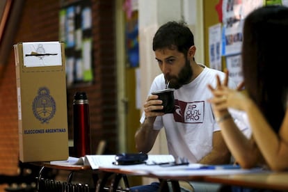 Un miembro de una mesa electoral en la ciudad de Buenos Aires, bebe un "mate", infusión tradicional a base de hierbas, a la espera de la llegada de ciudadanos para depositar su voto.