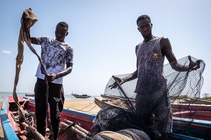 Los pescadores Mamadou Ndiaye y Alou Jaeng verifican el estado de las redes de pescar, el pasado abril en Albreda, Gambia.
