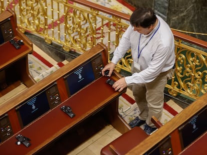 Un técnico coloca los auriculares de traducción en el hemiciclo del Congreso de los Diputados, este martes.