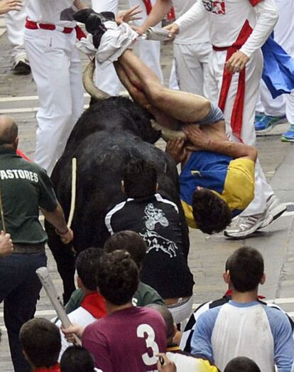 Un joven es empitonado en la calle Estafeta durante el sexto encierro de los sanfermines donde los toros de la ganadería del Pilar han protagonizado un peligrosísimo y largo sexto encierro.