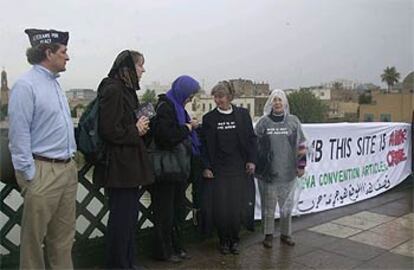 <i>Escudos humanos,</i> ayer en un puente de Bagdad, con un cartel que condena los ataques contra infraestructuras civiles.