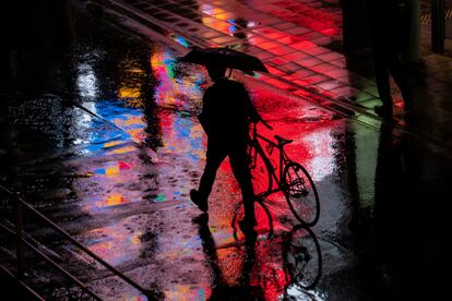 Un hombre caminaba en su bicicleta bajo la lluvia en Tokio, Japón, este lunes.