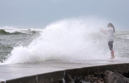 Valerie Barrington gets caught in a wave crashing ashore from the Gulf of Mexico as Hurricane Helene passes offshore on September 26, 2024 in St. Pete Beach, Florida. 