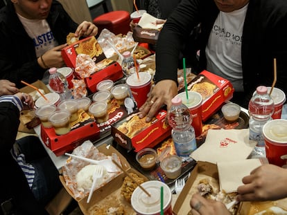 A group of friends eat ultra-processed food and sugary beverages at a restaurant in Italy.