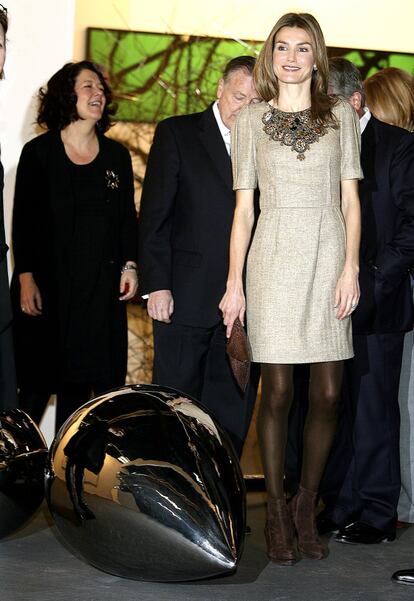 En 2010 doña Letizia escogió un minivestido de Varela en beige de manga corta con el cuello decorado a modo de collar-babero, que combinó con medias tupidas marrones, botienes de ante también de Varela y una cartera de mano del mismo tono.