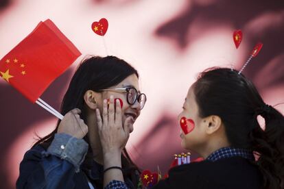 Dos jóvenes se divierten cerca de la plaza de Tiananmen durante la celebración del Día Nacional que marca el 66 aniversario de la fundación de la República Popular China, en Pekín, su capital.