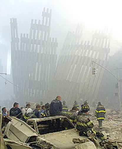 Varios bomberos toman un respiro durante las labores de rescate en las torres.