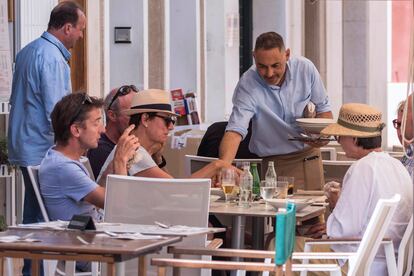 Un camarero servía a unos clientes, el jueves en una terraza en Maó (Menorca).