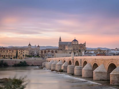 Atardecer en Córdoba, con el puente romano sobre el Guadalquivir, en primer término, y la mezquita-catedral, al fondo.
