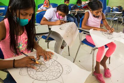 Un grupo de niños del resguardo indígena de Santa Sofía colorea dibujos de tortugas en un salón de su comunidad.