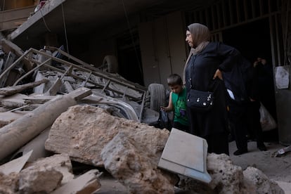 Supervivientes del ataque aéreo israelí caminan entre los escombros de un edificio, este viernes en Beirut.