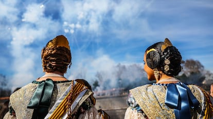 Dos falleras disfrutan de la 'mascletà' celebrada este domingo en Madrid Rio.