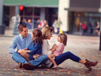 Una familia disfruta en el suelo de una v&iacute;a p&uacute;blica. 