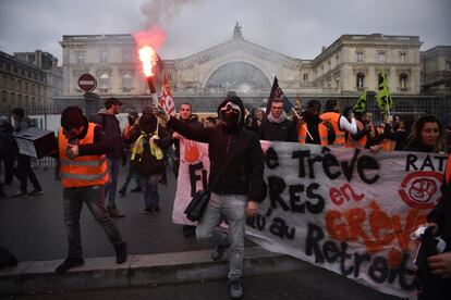 Un grupo de personas se manifiesta este jueves en la estación del Este de París contra la reforma de las pensiones. La huelga más larga de Francia no ha dado tregua en Navidades. El paro de los transportes contra la reforma de las pensiones ha superado esta semana los 20 días.