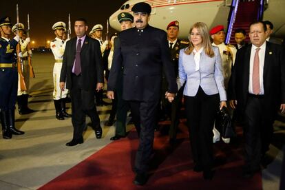 El presidente de Venezuela, Nicolás Maduro, camina con su esposa Cilia Flores a su llegada al aeropuerto en Pekín.