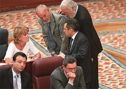 Rafael Simancas conversa con Esperanza Aguirre en el hemiciclo de la Asamblea de Madrid. De pie, los diputados del PP Luis Eduardo Cortés e Ignacio Echeverría. Sentados, Alberto Ruiz-Gallardón y Manuel Cobo.