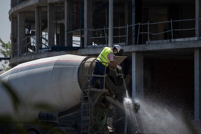 Un operario limpia con una pistola de agua a presión un camión hormigonera, en 2020.