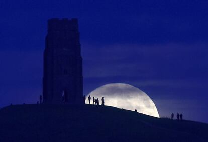 Un grupo de gente observa la Luna en la colina Glastonbury Torse (Reino Unido).