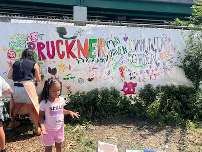 Vecinas del Bronx pintan una manta para el jardín comunitario en un evento organizado para las infancias de la comunidad.