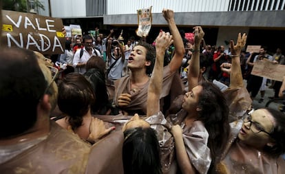 Manifestantes seguram cartaz com os dizeres: Vale nada.