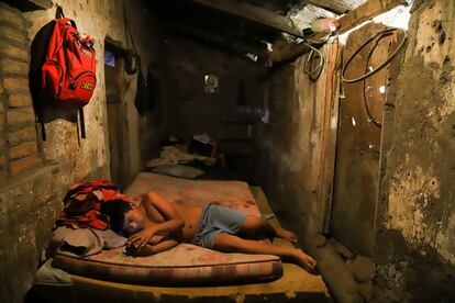 Cesar Velasquez, 14, lies on a mattress, while spending time with his cell phone, at his grandmother's house where he now lives, because his parents were detained during the government's crackdown on its war against drugs, in Santa Ana, El Salvador, Wednesday, Jan. 31, 2024.