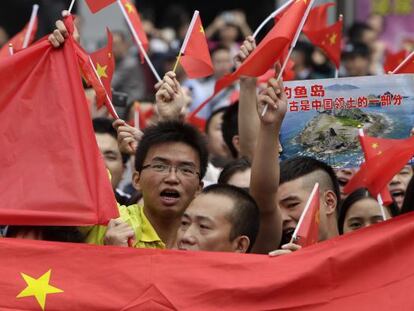Manifestantes enarbolan banderas chinas para reclamar la soberan&iacute;a de Pek&iacute;n sobre las islas Diaoyu, que Jap&oacute;n considera suyas.