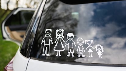 Un coche con pegatinas de una familia en el exterior