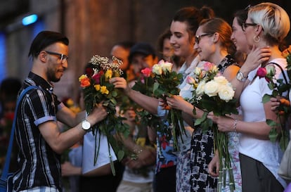 Mulheres dão flores a um homem que sai da mesquita de FInsbury Park.