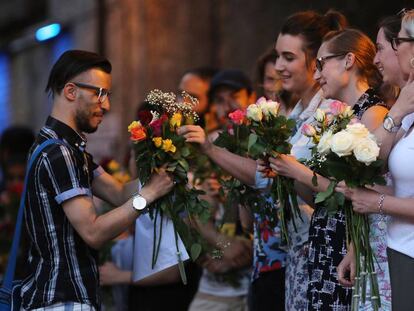 Mulheres dão flores a um homem que sai da mesquita de FInsbury Park.