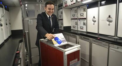 Un personal de cabina de Iberia recicla una botella de plástico durante un vuelo, como parte de la iniciativa Zero Cabin Waste.