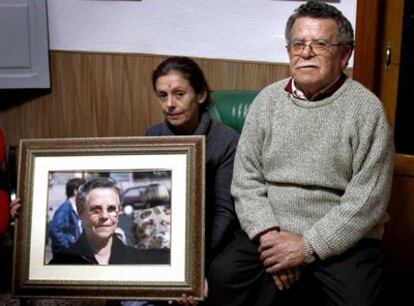 Amparo sostiene un retrato de su madre acompañada de su padre en la casa de éste.