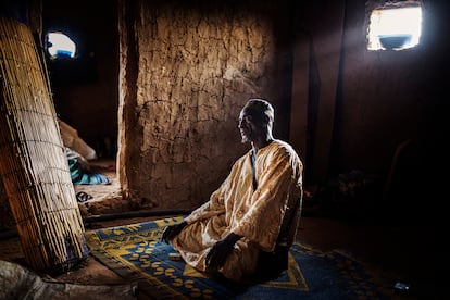 El comerciante de ganado Mahmoud Dicko reza en su nueva casa en la localidad de Dori, en el norte de Burkina Faso, después de abandonar su pueblo, Arbinda, a consecuencia de la violencia. Dicko se trasladó 80 kilómetros a pie durante tres días junto a una veintena de miembros de su familia. Hoy conviven todos en este pequeño espacio.