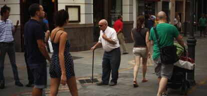 Un pensionista paseando por la calle entre varios jóvenes.