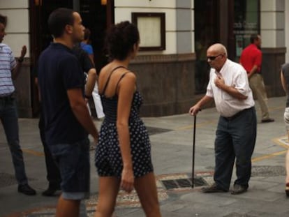 Un pensionista paseando por la calle entre varios j&oacute;venes.