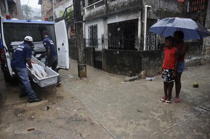 La policía forense se lleva el cuerpo de Rodrigo, un travesti disparado en una de las calles de Alto do Cabrito, Salvador de Bahía (Brasil).