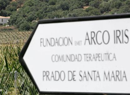 Al fondo, el centro de menores Arco Iris, en Hornachuelos (Córdoba). En primer plano, el cartel del desvío.