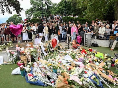 Un grupo de personas observa el homenaje espontáneo con ramos, peluches y globos a las víctimas del ataque de este jueves en los Jardines de Europa de la ciudad francesa de Annecy.