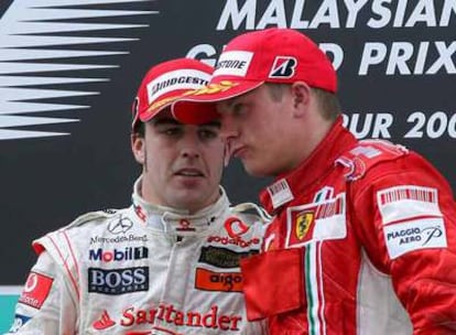 Fernando Alonso intercambia impresiones con Kimi Raikkonen en el podio del circuito de Sepang.