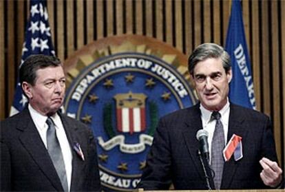 El director del FBI, Robert Mueller, se dirige a los informadores en presencia del fiscal general, John Ashcroft.