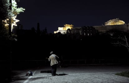 A street musician plays the guitar below the hill of the Acropolis in Athens, Greece, December 23, 2015. REUTERS/Michalis Karagiannis