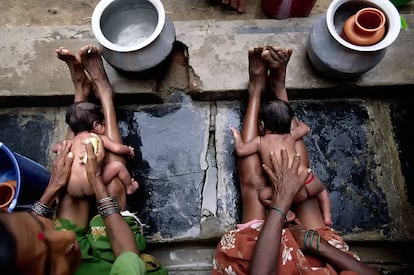 Dos abuelas bañan a sus nietos en el Hospital Pediátrico de Bathalapalli (India).