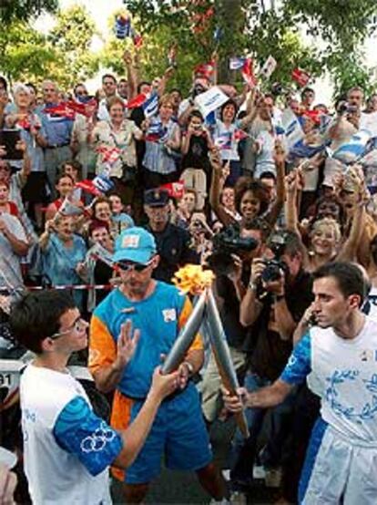 El recorrido de 50 kilómetros por las calles de Barcelona ha contado con 126 relevistas, entre ellos deportistas, personalidades famosas y ciudadanos anónimos. En la foto, el ex ciclista Javier Ochoa recibe el fuego olimpico de un joven voluntario, Roger Vilaseca.