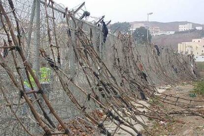 Decenas de escaleras fabricadas con ramas se apilan sobre la valla fronteriza de Ceuta horas después del intento de asalto de cientos de inmigrantes.